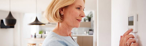 Woman adjusting thermostat