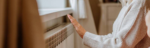 Woman warming up in front of a heating unit