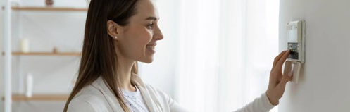 Woman adjusting thermostat